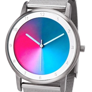 May include: A silver wristwatch with a gradient dial, transitioning from pink to blue. The watch has a white border with black numerals and white hands. The band is a fine mesh of silver metal.