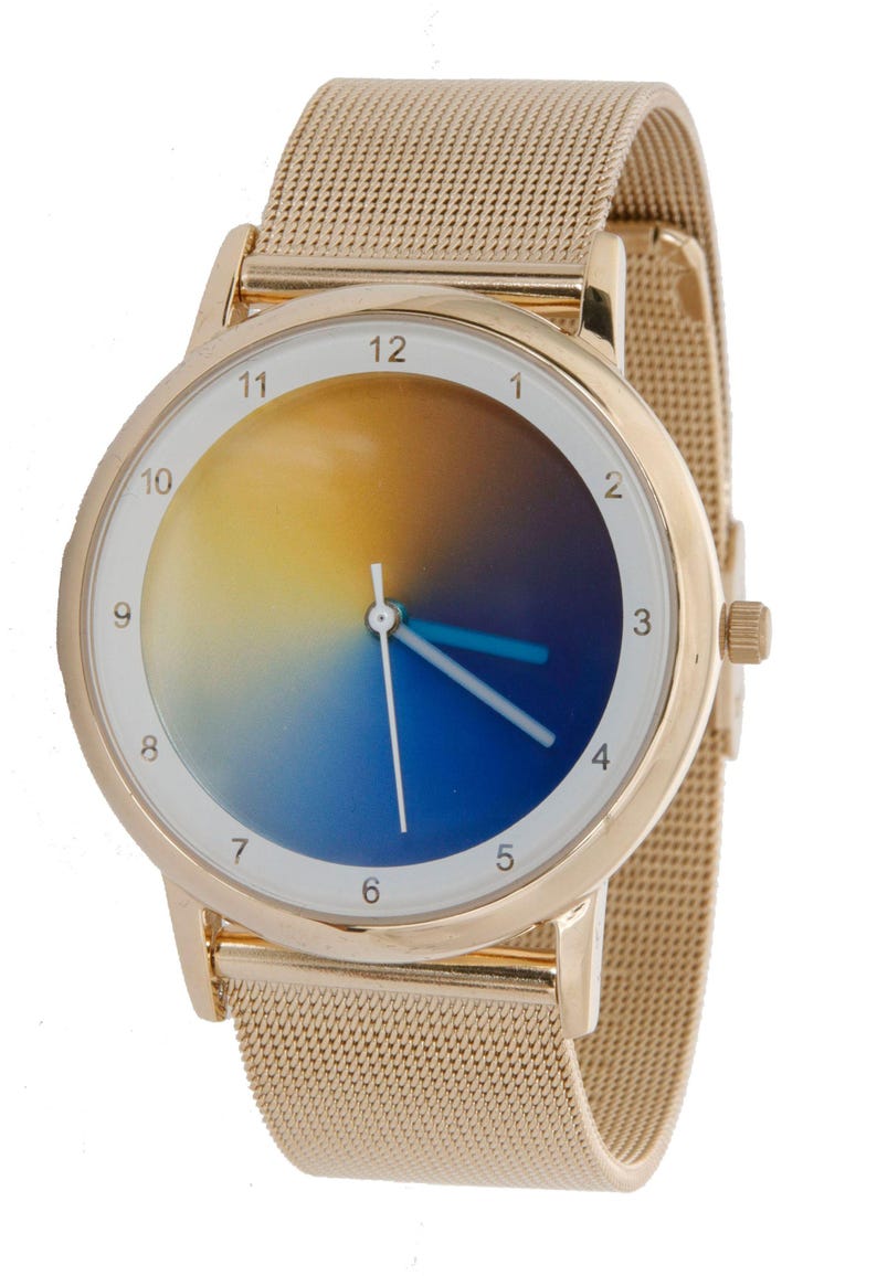 May include: Gold-toned wristwatch with a mesh band. The watch face features a gradient design, transitioning from yellow to blue. The watch has white numerals and blue hands. A stylish accessory.