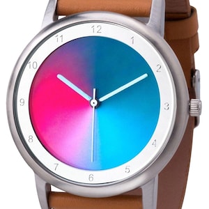 May include: A wristwatch with a silver-colored case and a brown leather band. The watch face is divided into two halves, one pink and one blue, with white hands and hour markers. The watch is a stylish accessory.