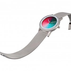 May include: A modern wristwatch with a silver-tone case and a mesh band. The watch face features a gradient of red, green, and teal. The band is unclasped, showing the clasp mechanism. The watch is set against a white background.