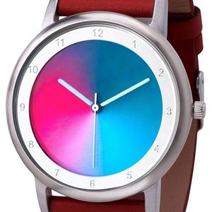 May include: A wristwatch with a silver case and a red leather band. The watch face is divided into pink and blue sections, with white hands and hour markers. The watch band is approximately 0.75 inches wide.