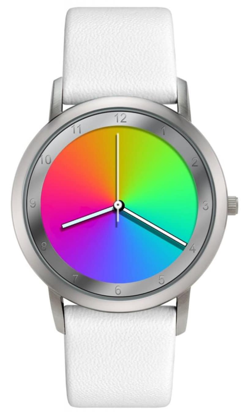 May include: A round wristwatch with a silver-colored case and a white leather strap. The watch face displays a vibrant rainbow gradient, with the hour and minute hands pointing to 12 and 3 o'clock. The watch has a simple, modern design.