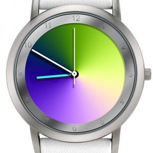 May include: A silver wristwatch with a white leather band. The watch face features a gradient of colors, including green, yellow, purple, and blue. The watch has silver hands and hour markers.