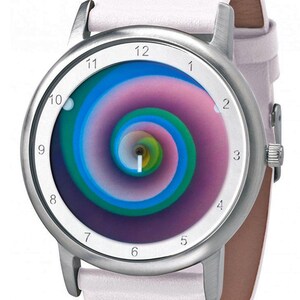 May include: A silver-toned wristwatch with a white leather band. The watch face features a colorful spiral design in shades of blue, green, and purple. The watch has a classic round shape with a white dial and black numerals.