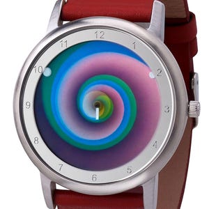 May include: A wristwatch with a silver-colored case and a red leather band. The watch face features a colorful spiral design in shades of blue, green, and pink. The watch has a classic analog display with numbers.
