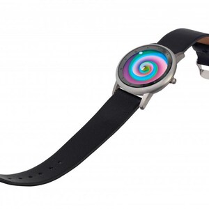 May include: A wristwatch with a black leather band and a silver-colored case. The watch face features a colorful, swirling design with shades of pink, blue, and green. The band is secured with a silver buckle.