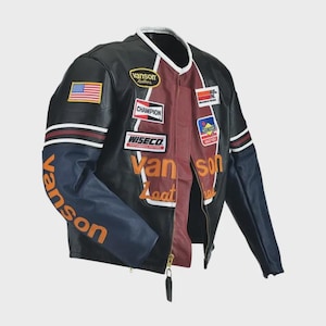 May include: A black, maroon, and navy blue leather motorcycle jacket featuring multiple embroidered patches including Vanson, Champion, and Wiseco logos. The jacket displays an American flag patch on the right sleeve and orange Vanson Leathers text.
