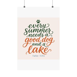 May include: A vertical rectangular wall poster featuring a light cream background with dark green and orange cursive text that reads: every summer needs a good dog and a lake, with a small green paw print above and the words lake life below.