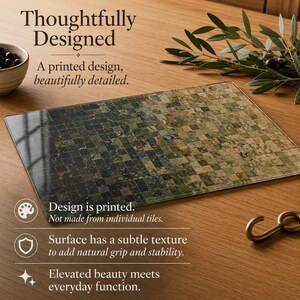 May include: A rectangular glass cutting board featuring a printed mosaic tile pattern that transitions from dark green to light beige. The surface has a subtle texture for grip. Text on the image reads: Thoughtfully Designed, A printed design, beautifully detailed, Design is printed, Not made from individual tiles, Surface has a subtle texture to add natural grip and stability, Elevated beauty meets everyday function.