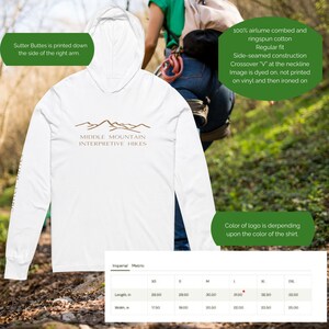 May include: White hoodie with the text "Middle Mountain Interpretive Hikes" in brown. The text "Sutter Buttes" is printed down the right arm. Made of 100% airlume combed and ringspun cotton. Regular fit with side-seamed construction.