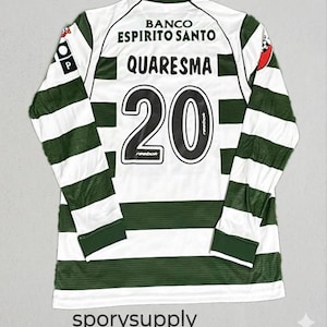 Peut inclure: Un maillot de football à manches longues avec des rayures vertes et blanches. Le dos affiche le nom "QUARESMA" au-dessus du numéro "20" en noir. Les mots "BANCO ESPIRITO SANTO" sont imprimés au-dessus du nom. Le logo Reebok est visible.