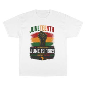 Puede incluir: Una camiseta blanca de manga corta con un gráfico que incluye el texto JUNETEENTH, ESTABLISHED JUNE 19, 1865, y FREEDOM, HERITAGE, CULTURE, PRIDE. El diseño muestra un puño negro alzado sobre un fondo de pinceladas rojas, amarillas y verdes.
