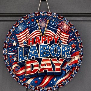 Könnte beinhalten: Ein rundes Wandschild mit patriotischem Motiv und dem Text HAPPY LABOR DAY in fetter, erhabener Schrift. Das Design zeigt amerikanische Flaggen, rote und blaue Feuerwerke sowie weiße Sterne auf einem dunkelblauen Hintergrund mit roten Akzenten.