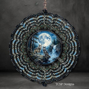 May include: A circular wind spinner featuring a central image of two wolves standing on a rocky outcrop before a waterfall and a large full moon. The outer frame has a layered, scalloped design with blue and black patterns. TCSP Designs is printed.
