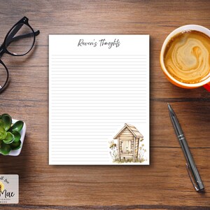 Puede incluir: Un bloc de notas con el texto "Raven's thoughts" y una ilustración de una colmena, una taza de café, gafas, un bolígrafo y una planta suculenta sobre una superficie de madera. El bloc de notas tiene páginas rayadas.