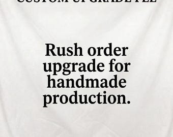Puede incluir: Un letrero blanco con texto negro que dice CUSTOM UPGRADE FEE, Rush order upgrade for handmade production y Message me before purchasing. El fondo tiene una textura sutil similar a la tela con pliegues suaves.