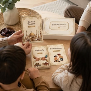 Könnte beinhalten: Eine Familie sitzt um einen Holztisch und betrachtet illustrierte Karten und eine Box. Die Karten zeigen Bilder und Text auf Türkisch und Deutsch. Eine Karte zeigt "Kurban Bayrami" mit einer Moscheedarstellung. Die Box hat Text auf Deutsch.