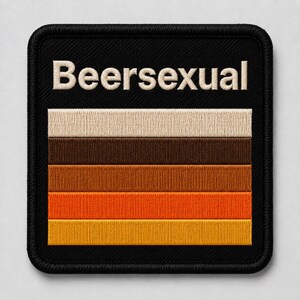 Könnte beinhalten: Ein quadratischer gestickter Aufnäher mit schwarzem Hintergrund und schwarzem gesticktem Rand. Der Text Beersexual ist oben in Weiß eingestickt. Unter dem Text befinden sich fünf horizontale Streifen in Beige, Dunkelbraun, Braun, Orange und Gelb.