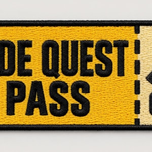 May include: A rectangular embroidered patch shaped like a ticket with a black border. The left side is yellow with the black text SIDE QUEST PASS. The right side is cream-colored with a black key icon above the number 001 and a dashed line.