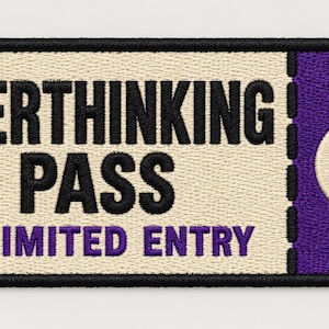May include: A rectangular embroidered patch shaped like a ticket with a black border. The left side is cream-colored with black text reading OVERTHINKING PASS and purple text reading UNLIMITED ENTRY. The right side is purple with a cream refresh icon.