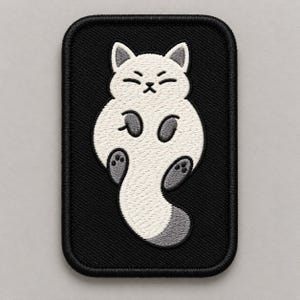 May include: A rectangular embroidered patch featuring a white cat with gray paws and a gray-tipped tail on a solid black background. The cat is depicted in a lying position with its eyes closed, and the patch has a thick black stitched border.