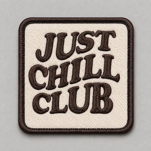 May include: A square embroidered patch with rounded corners featuring a cream-coloured fabric background and dark brown stitched borders. The text JUST CHILL CLUB is embroidered in a bold, dark brown, rounded font across the centre of the patch.
