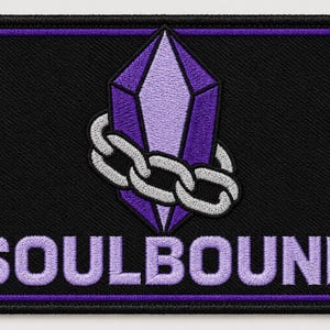 Könnte beinhalten: Ein rechteckiger bestickter Aufnäher mit schwarzem Hintergrund und violettem Rand. Das Design zeigt einen zentralen violetten Kristall, der von einer silbernen Kette umschlungen ist. Unter dem Motiv steht das Wort SOULBOUND in hellvioletten Großbuchstaben.