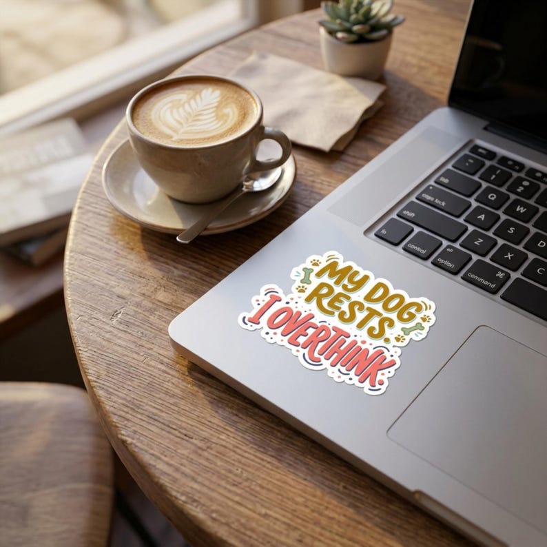 May include: A die-cut sticker featuring the text MY DOG RESTS I OVERTHINK in a playful font. The words are colored in mustard yellow and coral pink, accented with small green bone icons and paw prints, all set against a white background.