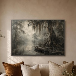 May include: A rectangular wall art print featuring a monochromatic landscape of a calm, misty swamp. A small wooden rowboat floats on the dark water near large cypress trees draped in Spanish moss. The scene is rendered in muted shades of grey.