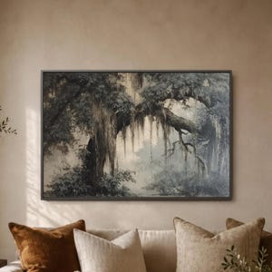 May include: A framed landscape painting depicting a large tree with hanging moss, rendered in shades of gray and white. The artwork has a dark frame and evokes a serene, natural scene, suitable for home decor.
