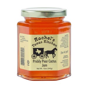 May include: A jar of Rachel's Texas Kitchen Prickly Pear Cactus Jam. The label features a stagecoach illustration and the text "Net Wt. 12oz (340g)." The jam is a vibrant orange color, visible through the clear glass jar.