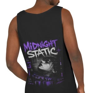 May include: A black tank top featuring a graphic print on the back. The design includes the text "MIDNIGHT STATIC" in purple and white, a black and white portrait of a face, and a purple cityscape silhouette at the bottom of the graphic.