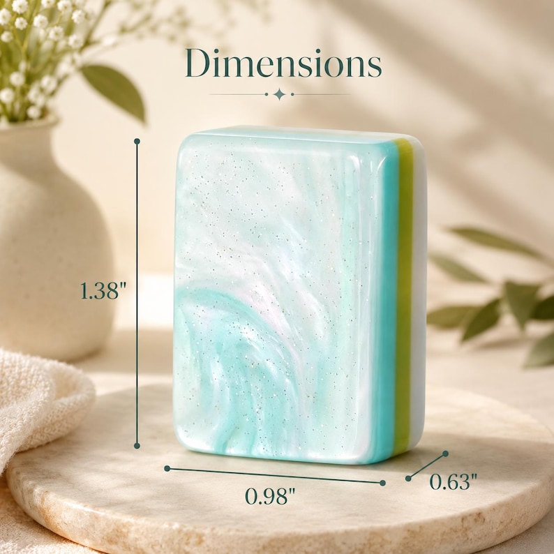 May include: A rectangular mahjong tile featuring a marbled light blue and white surface with subtle glitter accents. The side displays a vertical green stripe. The tile measures 1.38 inches in height, 0.98 inches in width, and 0.63 inches in depth.
