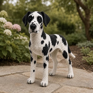 May include: A handmade crochet Dalmatian dog with a black and white spotted pattern. The dog is standing on a stone surface, with a natural background of greenery and flowers. The dog's features are detailed, including its ears, nose, and paws.