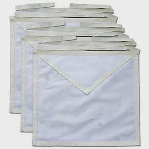 May include: A set of three plain white ceremonial aprons, each featuring a square body with a triangular flap at the top and integrated fabric waist ties. The aprons are constructed from a smooth, solid white fabric with matching white trim.