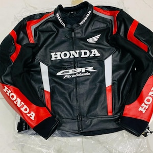 Könnte beinhalten: Eine schwarz-rot-weiße Motorradjacke mit Honda-Logo auf Brust, Kragen und Ärmeln. Auf der Vorderseite steht der Schriftzug Honda und CBR Fireblade. Die Jacke verfügt über einen durchgehenden Frontreißverschluss, perforierte Einsätze und einen Stehkragen.