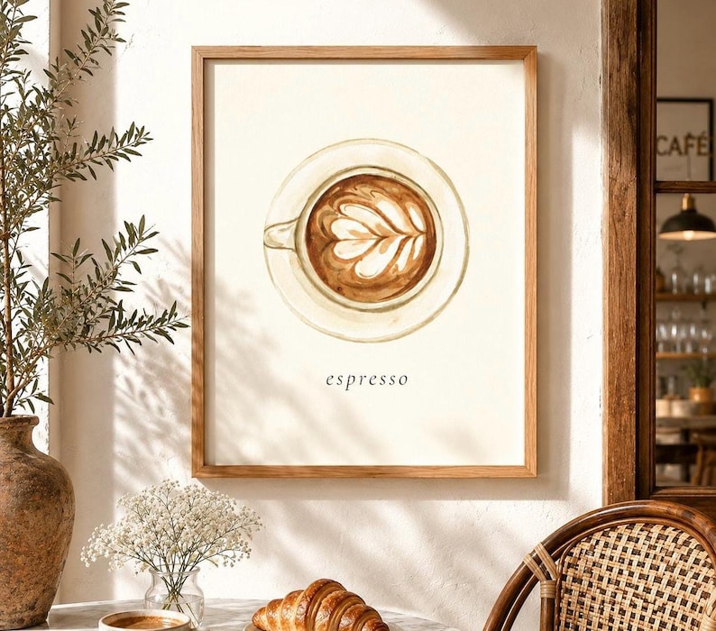K&ouml;nnte beinhalten: Ein gerahmter Kunstdruck mit einer Aquarellillustration einer Kaffeetasse mit Latte-Art-Motiv in der Draufsicht. Der Hintergrund ist cremewei&szlig; und das Wort espresso ist in einer einfachen schwarzen Serifenschrift unter der Tasse gedruckt.