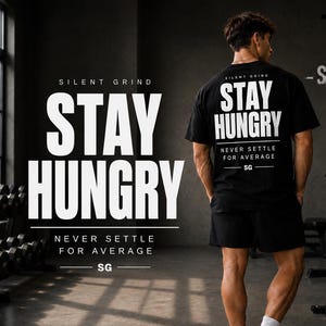 May include: Black t-shirt and shorts with the text "STAY HUNGRY" and "NEVER SETTLE FOR AVERAGE". The image shows a person in a gym setting, with weights and equipment visible in the background. The brand logo "SG" is also displayed.