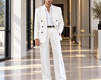 May include: A white double-breasted suit jacket with black buttons, a white collared shirt, and matching white wide-leg trousers. A thin black belt with a gold buckle is worn at the waist. The text dapper tux is visible on the right side.