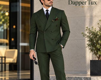May include: A dark olive green double-breasted suit featuring a peaked lapel, a black necktie, and a patterned pocket square. The suit jacket has six buttons and the text Dapper Tux is visible in the upper right corner of the image.
