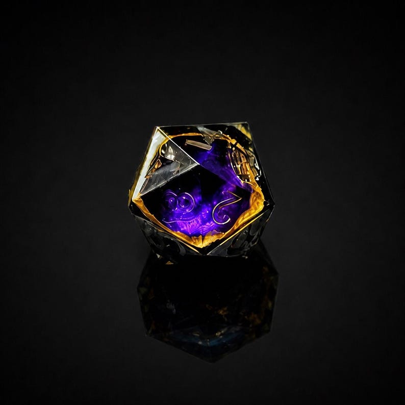 K&ouml;nnte beinhalten: Ein D20-W&uuml;rfel aus klarem Harz mit einem violett-goldenen Inneren. Der W&uuml;rfel hat goldene Zahlen und ist vor einem schwarzen Hintergrund platziert. Die Reflexion des W&uuml;rfels ist auf der Oberfl&auml;che sichtbar. Ein beliebtes Objekt f&uuml;r Tabletop-Spiele.