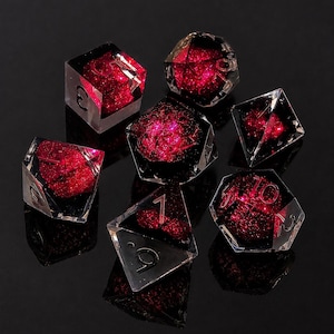 Puede incluir: Un juego de siete dados poliédricos hechos de resina transparente con un núcleo magenta brillante y con purpurina. Cada dado presenta bordes afilados y números grabados en negro. El set incluye un d20, d12, d10, d8, d6, d4 y un dado porcentual.