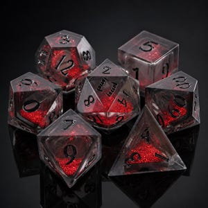 May include: A set of seven polyhedral dice made of clear resin with bright red glitter suspended inside. Each die features sharp edges and black engraved numbers. The collection includes various geometric shapes used for tabletop gaming.