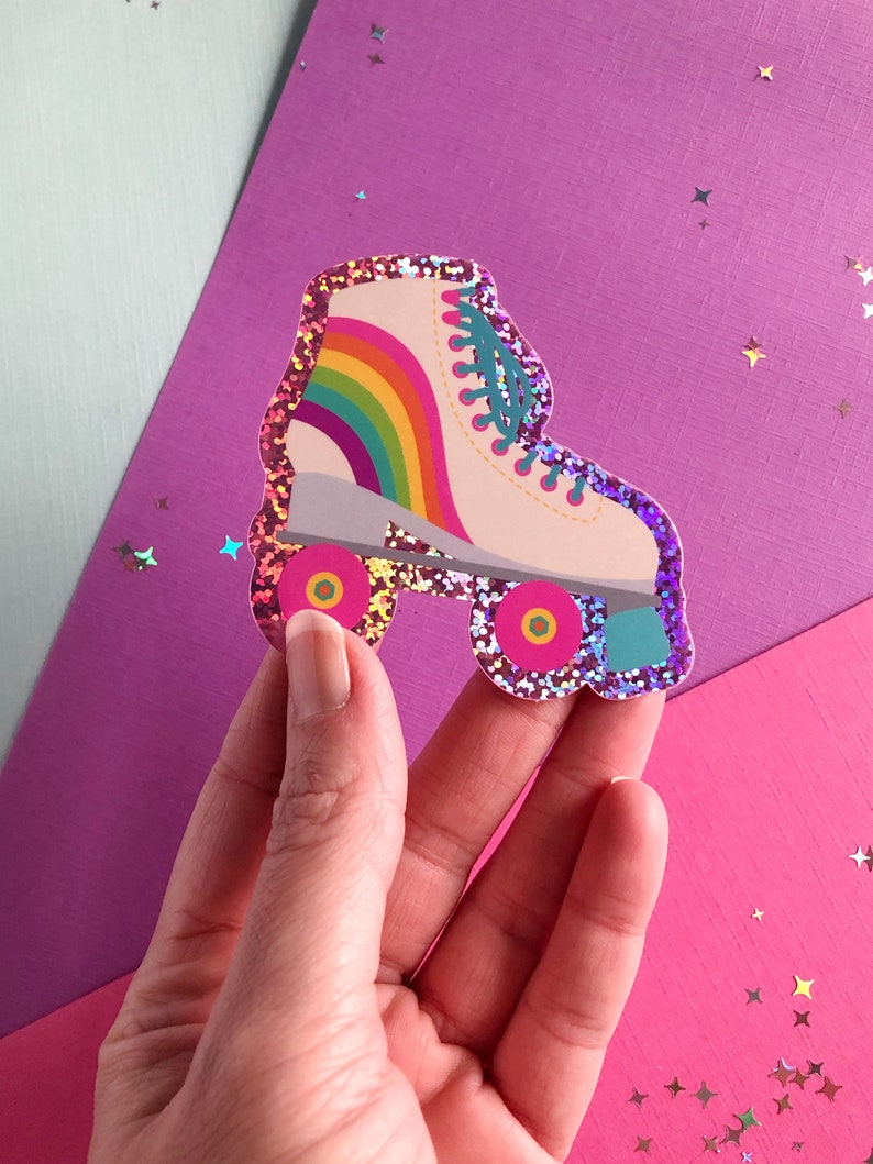 May include: A pink glitter roller skate sticker with a rainbow on the side. The wheels are red and yellow.
