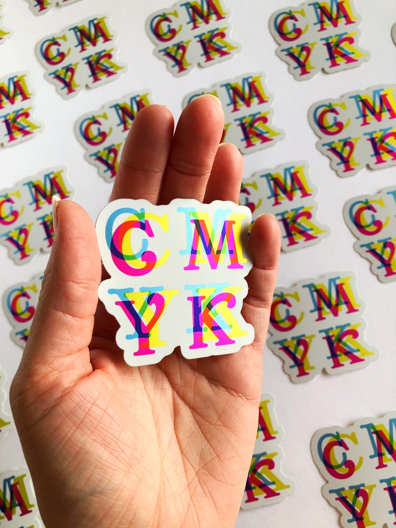 May include: A sticker with the letters CMYK in a rainbow color scheme. The letters are layered on top of each other, creating a 3D effect.
