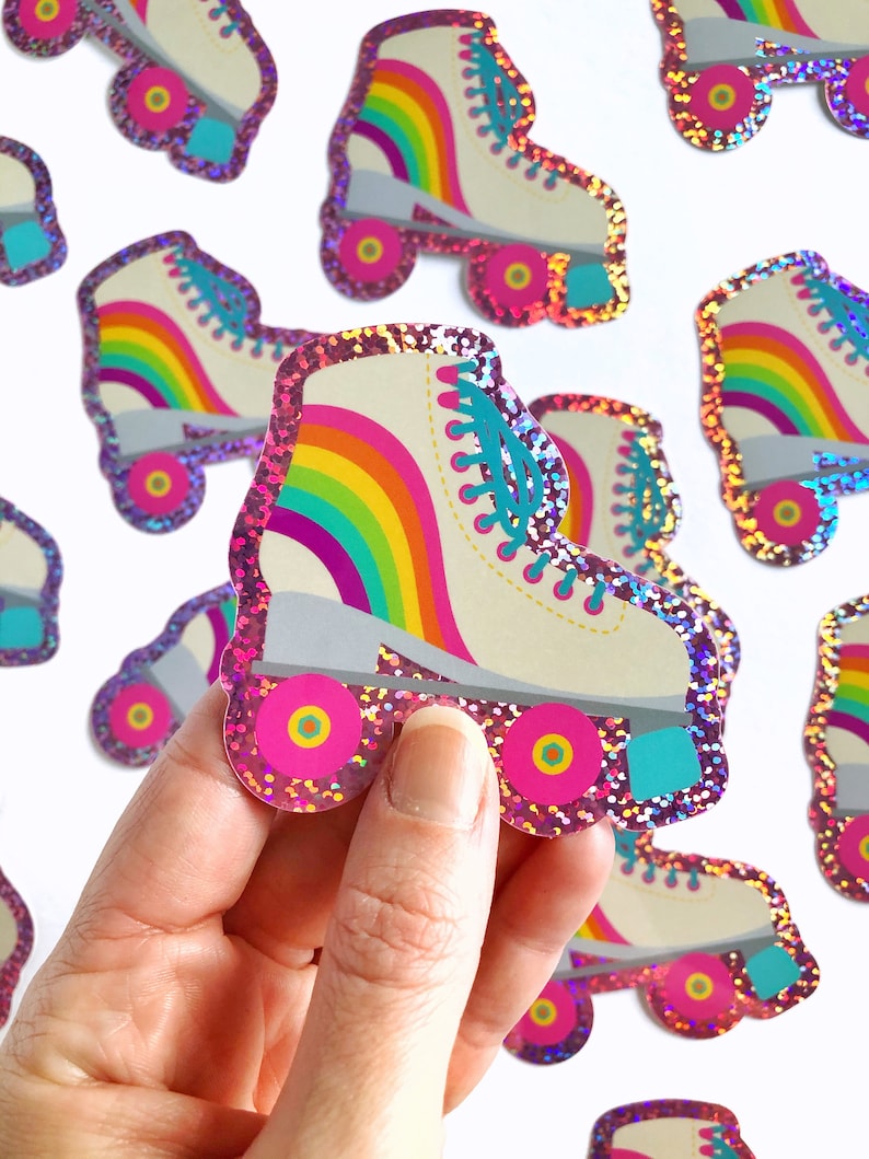 May include: A set of rainbow roller skate stickers with pink glitter. The stickers are in the shape of a roller skate with a rainbow design on the boot and pink wheels.