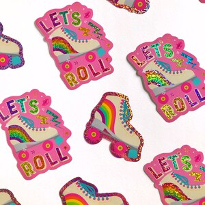 May include: Pink and white roller skate stickers with rainbow accents and the text "Let's Roll".