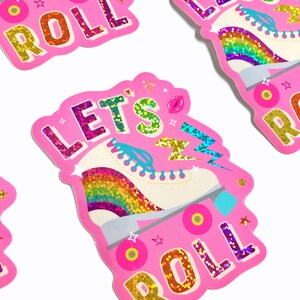May include: Pink sticker with a rainbow roller skate and the text "Let's Roll" in glittery letters.