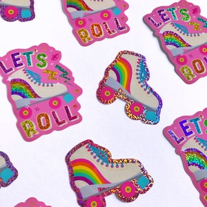 May include: Pink and white roller skate stickers with rainbow accents and glitter. The stickers say "Let's Roll" in a colorful font.