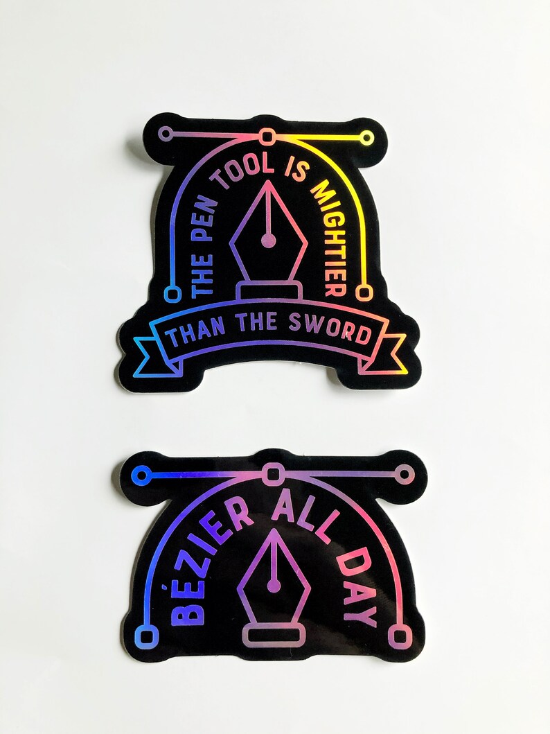 Puede incluir: Dos pegatinas negras y hologr&aacute;ficas iridiscentes con un dise&ntilde;o de plumilla. La pegatina superior dice "The pen tool is mightier than the sword". La pegatina inferior dice "Bezier all day".